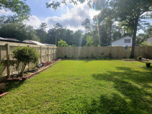 A newly installed wood privacy fence lining a backyard by FenceCo LLC in Pass Christian, MS.