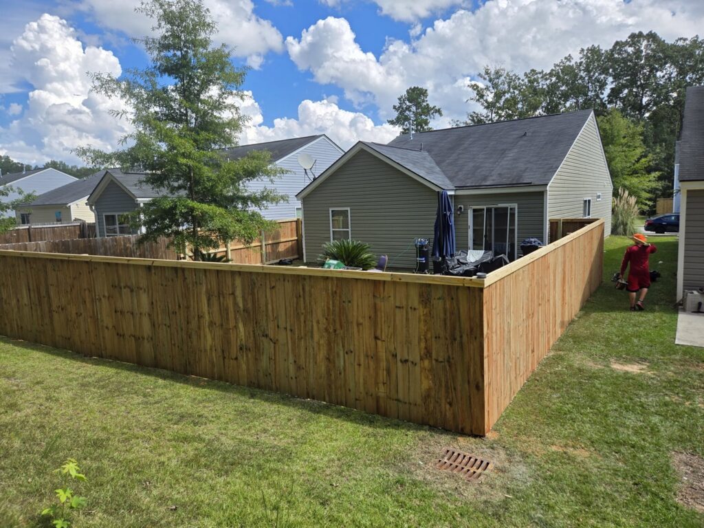 A newly installed wooden privacy fence enclosing a residential backyard by JB FENCE Brothers company llc in North Charleston, SC.