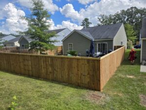 A newly installed wooden privacy fence enclosing a residential backyard by JB FENCE Brothers company llc in North Charleston, SC.