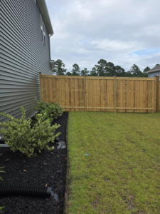 A backyard featuring a new wood privacy fence installed by Montiel Fence Works in Wilmington, NC.