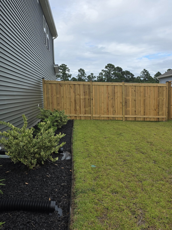 A backyard featuring a new wood privacy fence installed by Montiel Fence Works in Wilmington, NC.