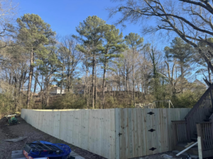 A long wood privacy fence with a gate in a backyard, installed by Precision Contracting LLC in Jupiter, FL.