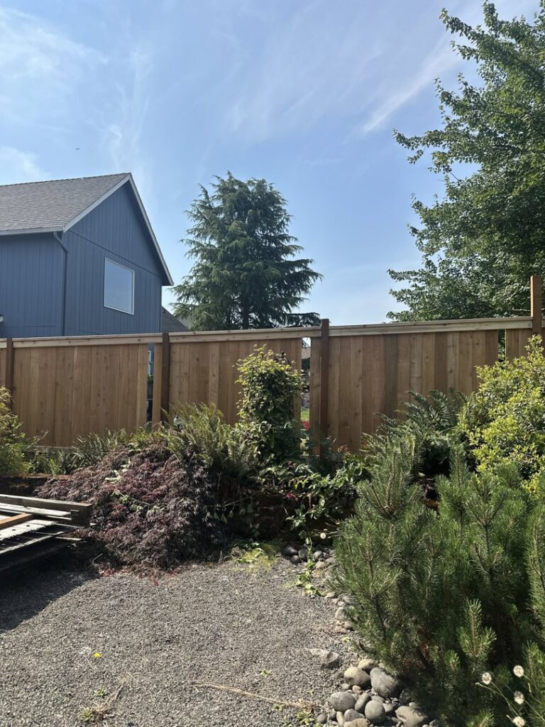 A tall, newly installed wood privacy fence defining a backyard boundary by RPB Fence in Salem, OR