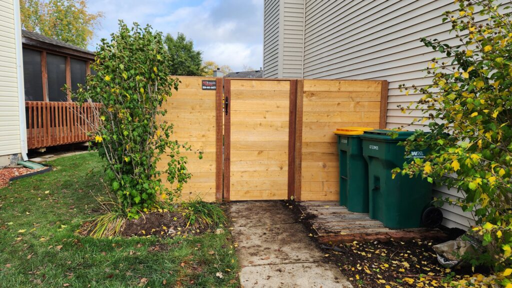 Backyard wood privacy fence installed among trees by All Terrain Fence LLC in Waukegan, IL