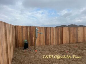 A new wood privacy fence installed in a backyard with utility equipment by C & M Affordable Fence, LLC in Haughton, LA