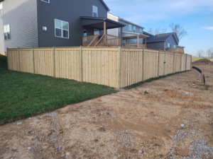 A newly installed wood privacy fence in a backyard by Veteran Fence in North Royalton, OH.