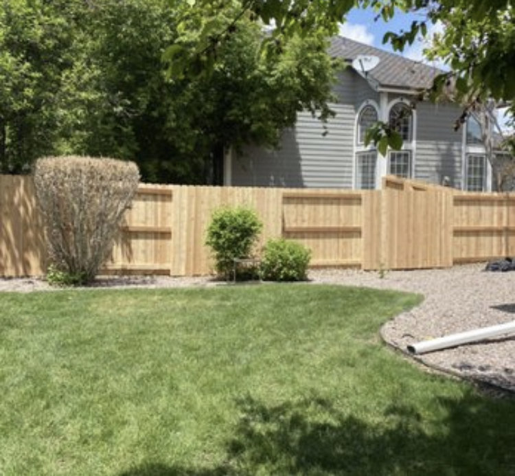 A backyard wood privacy fence with a gate, installed by R&S Fencing & Design LLC in Denver, CO.