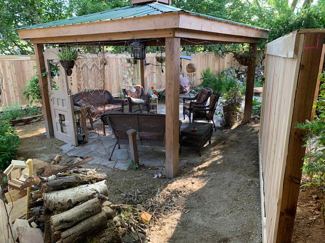 A newly installed wood privacy fence enclosing a backyard patio with a wooden gazebo, completed by Fence Guru LLC in Denver, CO.