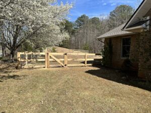 A newly installed backyard wood and wire mesh fence with a gate, expertly constructed by 865 Fencing in Knoxville, TN.