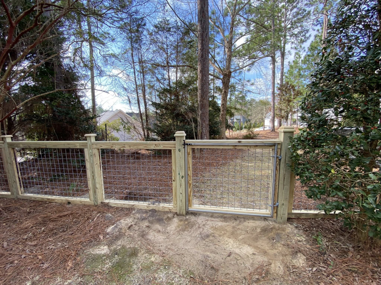 A backyard wood and wire mesh gate installed by Renegade Fencing, LLC, a fencing contractor in Jacksonville, NC.