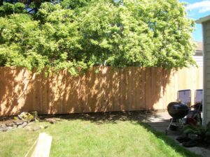 A newly installed wooden privacy fence in a residential backyard by Fix-A-Fence LLC in Portland, OR.