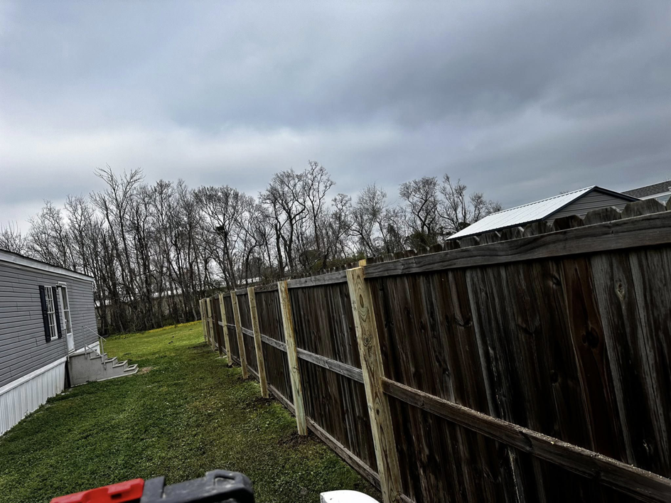 A backyard wooden fence with new support posts installed by Gator Fence Co. in Miami, FL