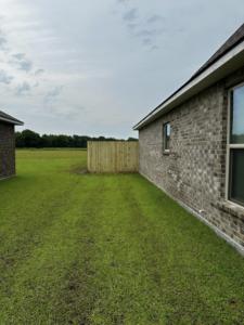 A newly installed wooden privacy fence section in a backyard between two houses by J&L Fence in Zolfo Springs, FL.