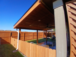 A backyard featuring a new wooden privacy fence and patio cover by Olson Handyman Services, LLC in New Braunfels, TX