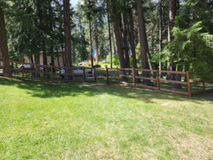 A backyard wooden fence with wire mesh and a gate, showcasing a completed project by EcoGreen Fencing in Coeur d'Alene, ID.