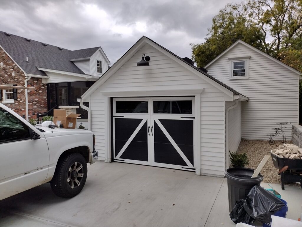 A white garage door with a black barn-style overlay installed on a residential garage by Honest Overhead Garage Doors in Elizabethtown, KY.