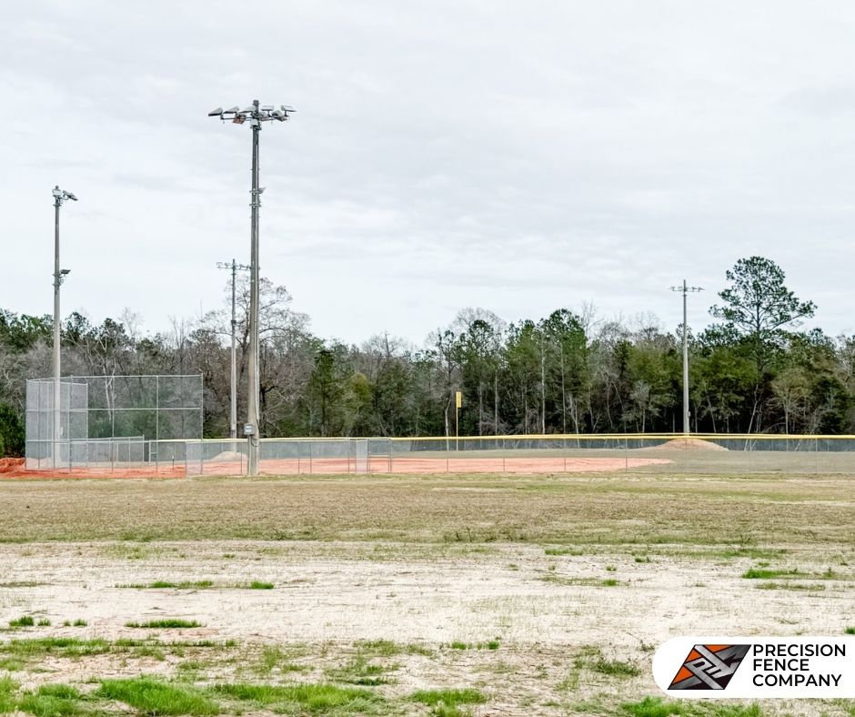 A chain link backstop and outfield fence installed at a baseball field by Precision Fence in Meridian, MS.