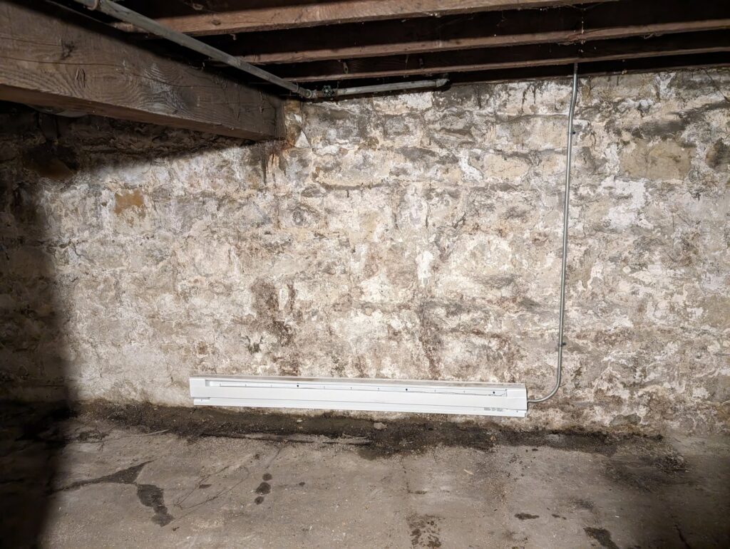 An electric baseboard heater installed in a basement by Be Bright Electric in Erie, PA.