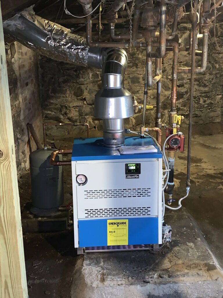 A new boiler or furnace installation by Call The Bee Plumbing, Heating, Air & Electric in a basement in Farmington, CT.