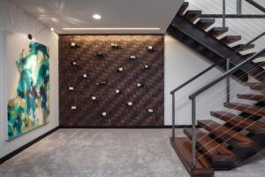A modern basement area with new gray carpet installed by Carpet World Fargo, ND, next to a wine wall