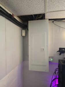 An electrical panel installed in a finished basement area by Be Bright Electric in Erie, PA.