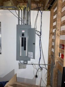 An electrical panel installed on a wall in a basement or utility area, showcasing the work of AA Electric Contractors in Chicago, IL.