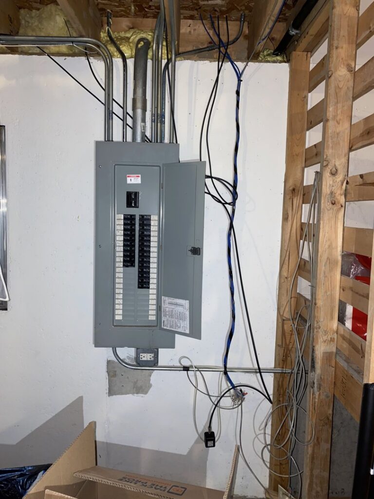 An electrical panel installed on a wall in a basement or utility area, showcasing the work of AA Electric Contractors in Chicago, IL.