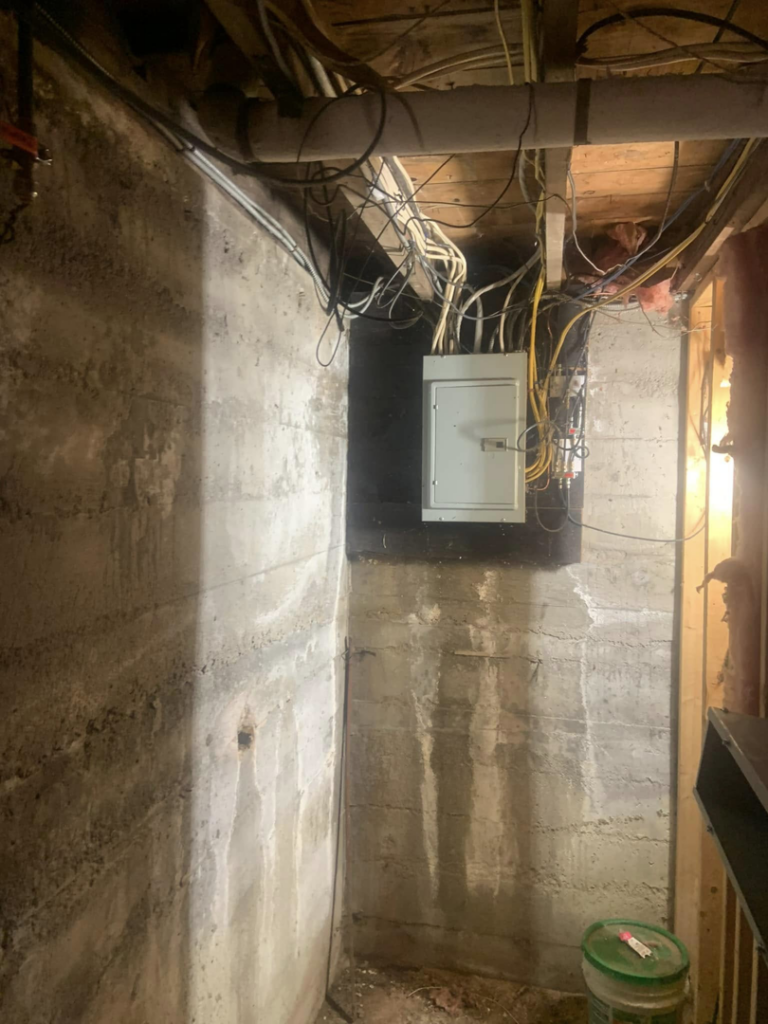 Electrical panel and wiring in a basement, serviced by EO Ross Electrical Contractors Inc. in Springfield, MA.