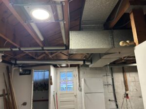 Exposed electrical wiring and conduit installed on a basement ceiling by Common Ground Electrical in Baltimore, MD.