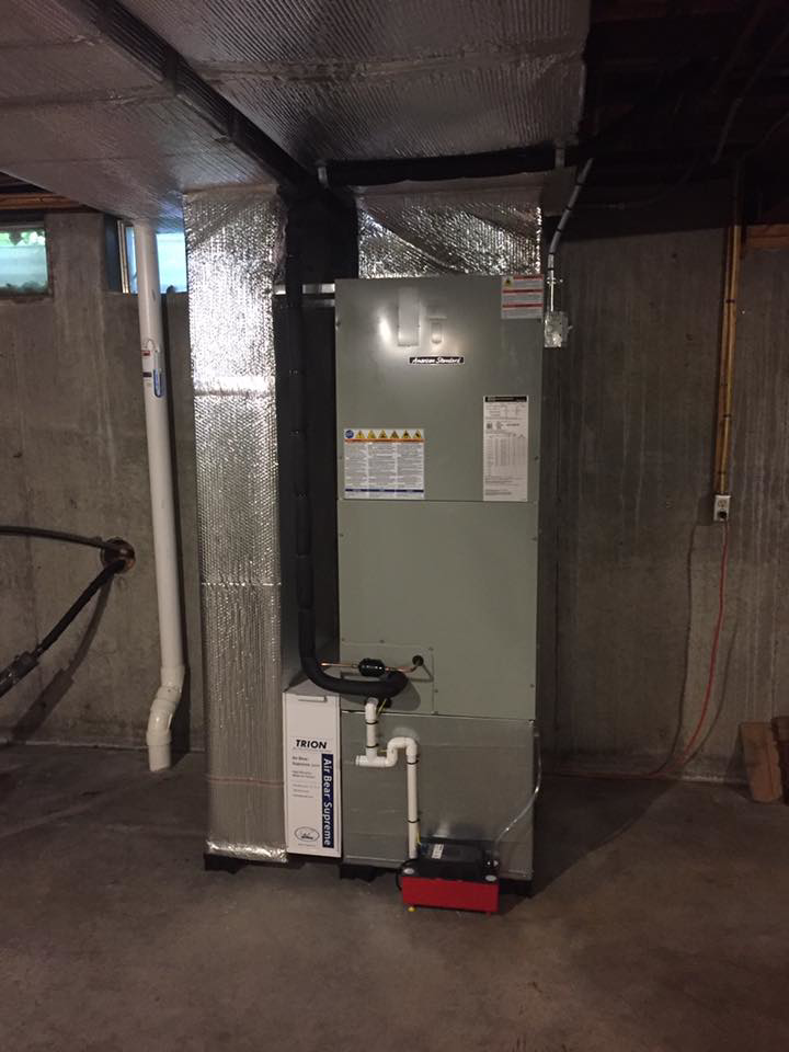 A furnace and air handler unit with ductwork installed in a basement by R&M Mechanical Services LLC in Londonderry, NH