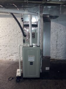 A new furnace or air handler unit with associated ductwork and piping installed in a utility room by Tack Mechanical LLC in Baltimore, MD.