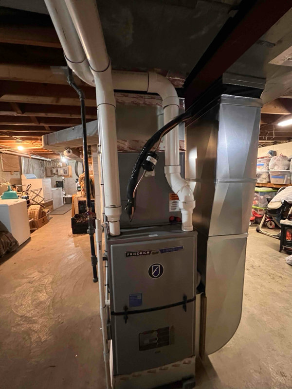 A furnace unit with complex ductwork and PVC piping installed in a basement by A-1 HVAC in Kansas City, KS.