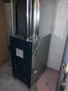 Modern furnace unit with metal ductwork installed in a basement by ALC Universal in Sheridan, WY.