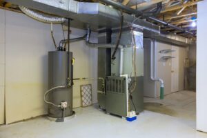A well-maintained basement showing a furnace, water heater, and extensive ductwork, serviced by Evergreen HVAC Comfort Solutions in Milwaukee, WI.