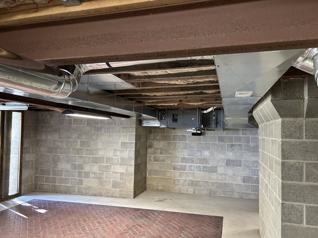 Newly installed HVAC ductwork and an air handler unit in a basement by Cool Tech Heating & Cooling in East Peoria, IL.