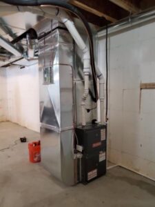 A Goodman HVAC furnace unit with extensive ductwork in a basement by Perfect Comfort Systems in San Bernardino, CA