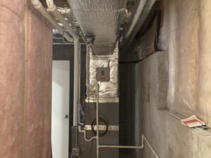 An HVAC system with ductwork installed in a basement by Freedom Air Mechanical Contractors LLC in Everett, MA.