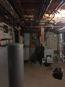 A complete basement HVAC system installation featuring a water heater and boiler by Nate's Oil Burner Service in New Bedford, MA