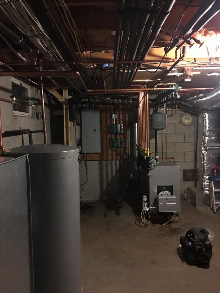 A complete basement HVAC system installation featuring a water heater and boiler by Nate's Oil Burner Service in New Bedford, MA