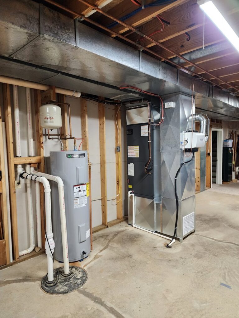 A complete basement HVAC system with furnace, ductwork, and water heater installed by Eades Heating & Air Conditioning in Springfield, IL.