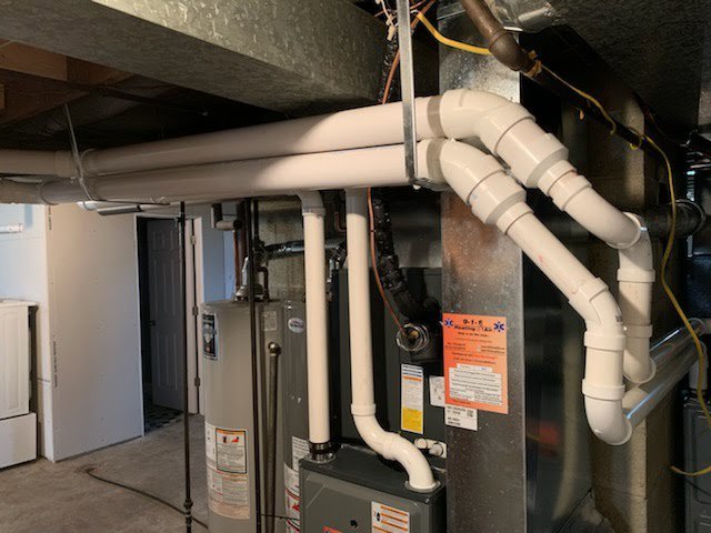 A basement installation showing a furnace, water heater, and complex piping by 9-1-1 Heating & Air, LLC in Milwaukee, WI.