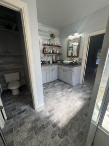 A modern bathroom with dark grey brick-patterned tile flooring installed by Carpet Direct Brandon Burley in Muskogee, OK