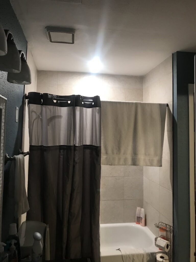 A bathroom with a bright ceiling light fixture installed by Christensen Electric in Galveston, TX.