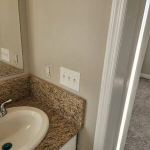 Bathroom wall showing electrical outlets and light switches during installation by Tim Lambert Electric in Fayetteville, NC.