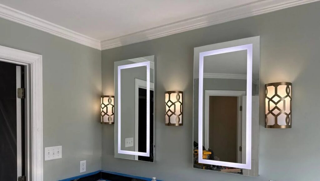 Bathroom with newly installed illuminated mirrors and wall sconces by Fresh Start Electrical, LLC in Newport News, VA