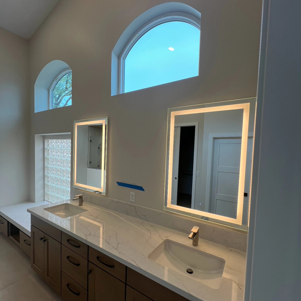 Newly installed lighted mirrors and electrical outlets in a modern bathroom by Silo Electric in Gilbert, AZ