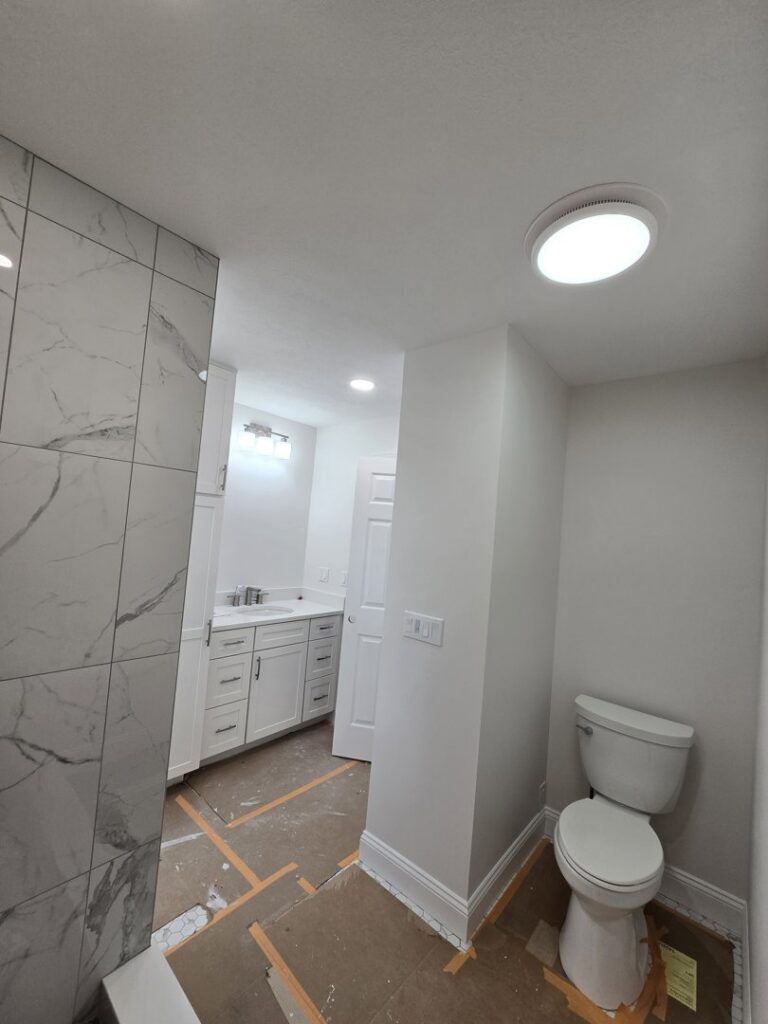 Modern bathroom lighting installation with recessed lights and a ceiling fixture by Be Bright Electric in Erie, PA.