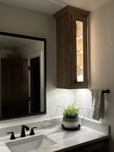 A modern bathroom vanity featuring lighted cabinet and under-cabinet lighting installed by Premier Power in Edmond, OK.