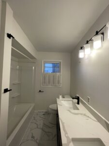Bathroom with new marble-look tile flooring installed by Mendez Carpet in Grand Rapids, MI.