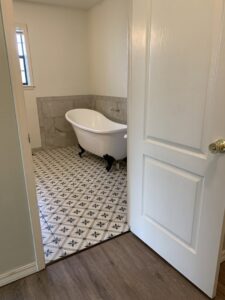 A bathroom with elegant patterned tile flooring and a clawfoot tub installed by Carpet Direct Brandon Burley in Muskogee, OK